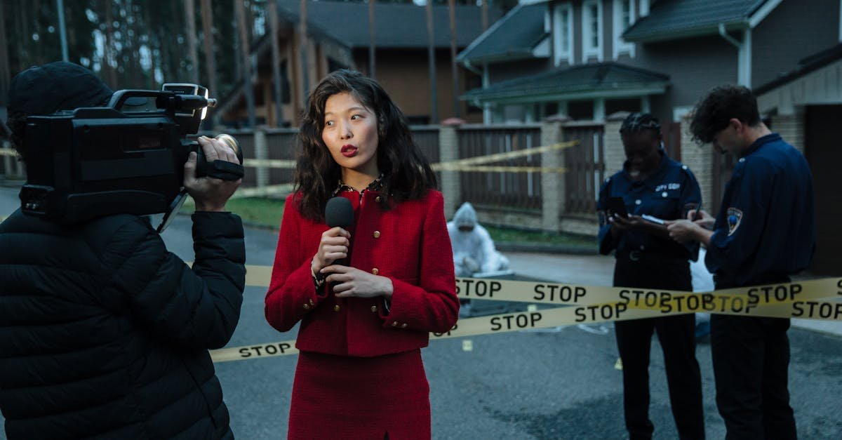 A journalist reporting from a crime scene with police officers and cameraman.
