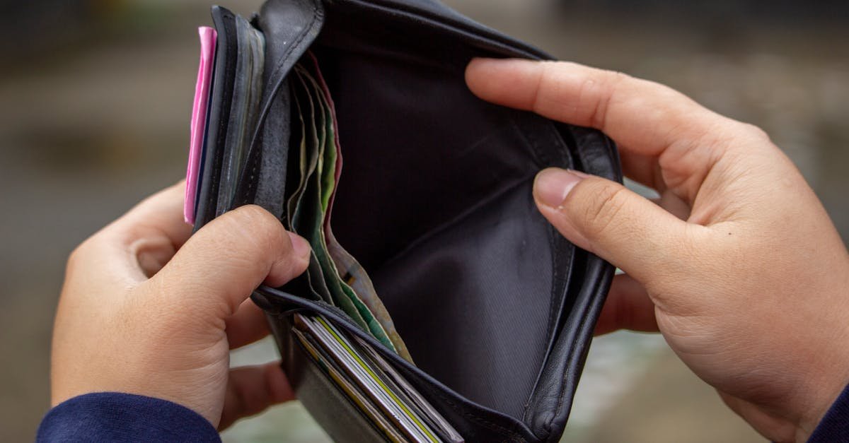 Hands holding an empty wallet, exploring themes of financial strain and budgeting.